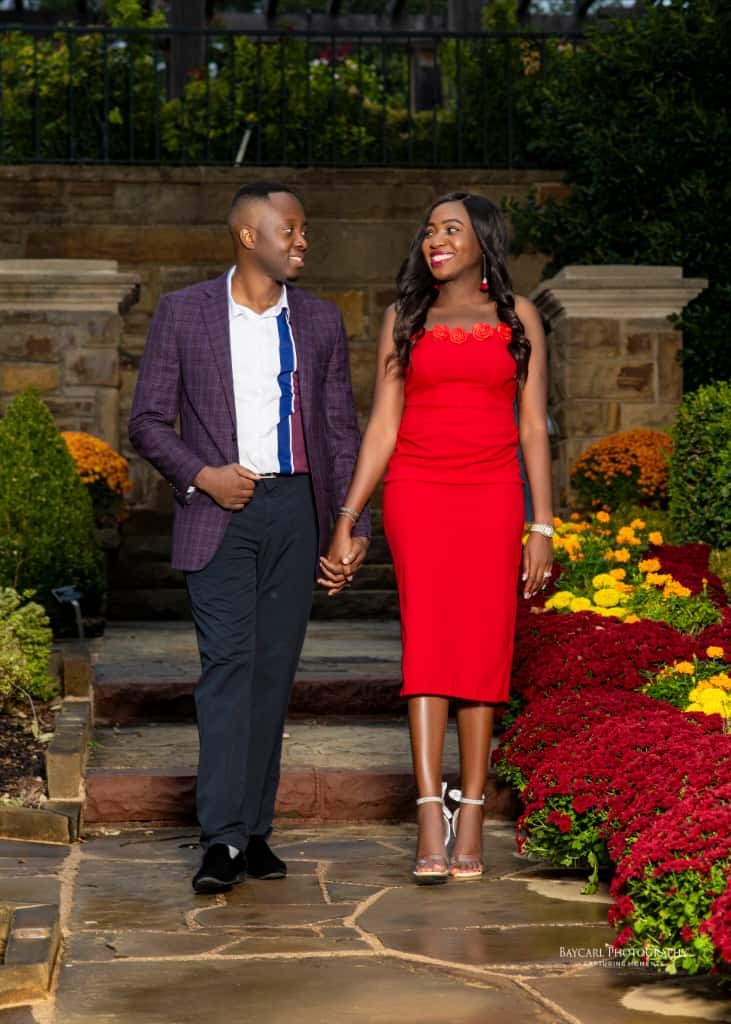 Tolu and Dami walking past autumn flowers